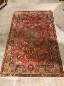 A hamadan rug with central floral medallion surrounded by foliate design, with multiple flowerhead