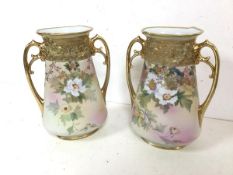 A pair of Noritake vases, of flattened bottle form with flared rim with handles to each side, on