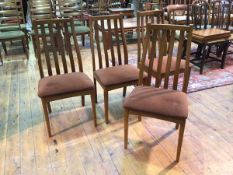 A set of four slat back armchairs with chocolate brown upholstered seats, stamped Dralon to base (