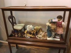 An Edwardian mahogany display cabinet with a collection of dolls and doll furniture including a