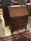 A 1930s/40s mahogany bureau, the interior fitted single shelf and pigeonholes, bears brass plaque