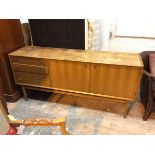 A teak mid century sideboard, with distressed top above four short drawers and two cabinet doors