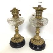 A near pair of oil lamps, both with glass gadrooned oil reservoirs, one marked W & W Kosmos (