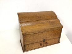 An oak stationery box with hinged lid, with section fitted interior above two doors to base (26cm