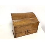 An oak stationery box with hinged lid, with section fitted interior above two doors to base (26cm