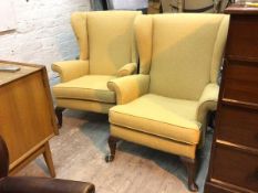 A pair of wing back armchairs, with multiple flowerhead pattern to fabric, with scroll arms, on