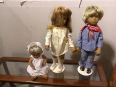 A collection of three Sasha dolls, including a Young Boy and Girl on stands, also Infant in