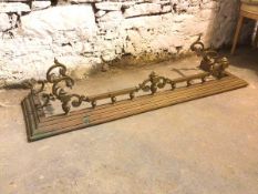 An Edwardian brass fender with raised endirons to sides supported by C scrolls and gallery to