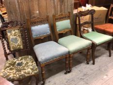 A pair of Edwardian oak side chairs with upholstered panel backs and stuffover seats (89cm x 44cm