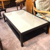 An Oka style black ash rectangular coffee table with inset panel and glass top, raised on square