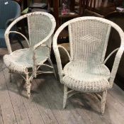 A pair of painted cane back side chairs with arched backs and open arms on shaped tapered