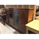 A 1950s figured mahogany bookcase, the rectangular top with moulded edge and plain frieze above a