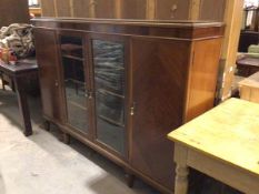 A 1950s figured mahogany bookcase, the rectangular top with moulded edge and plain frieze above a