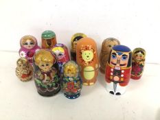 A collection of Russian nesting dolls, most with traditional female faces, others with animal
