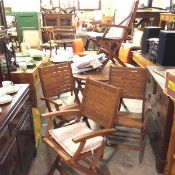 A hardwood five piece outside dining set comprising circular folding table and set of four folding