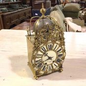 An H & F Paris reproduction brass lantern style clock, with turned finial and brass straps, above