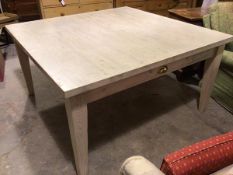 A bleached pine square top kitchen dining table fitted frieze drawer to each side, raised on