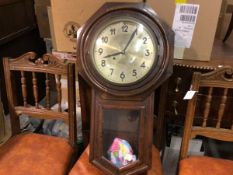 An AEG stained walnut octagonal wall clock with silvered dial, twin key apertures and glazed panel