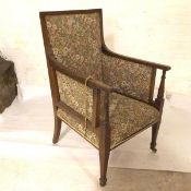 An Edwardian mahogany framed easy chair with upholstered panel back, arms and seat, in floral