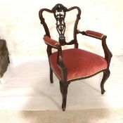 An Edwardian mahogany framed armchair with pierced foliate and swag carved splat back, with