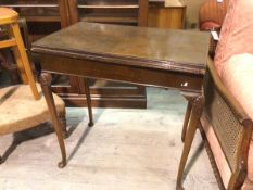 An Edwardian walnut foldover card table, the rectangular top with fluted edge above a plain frieze