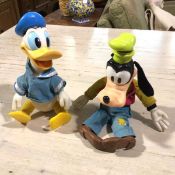 A Walt Disney early plastic stuffed Donald Duck and Goofy figure, dressed in typical clothing of the