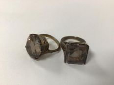 Two rings each set a light grey stone, one oval cut, the other square cut, both in gilt metal mounts