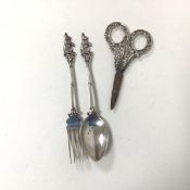 A white metal fork and spoon, both with rabbit finials and a pair of silver handled scissors,