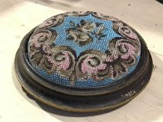 A Victorian ebonised and brass mounted circular beaded top footstool raised on bun feet (6cm x d.