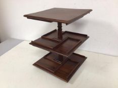 A table top revolving bookcase, the two tiers with raised rectangular edges (30cm x 23cm x 23cm)