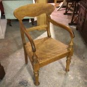 A 19thc stained beech Edinburgh pattern kitchen open armchair, with curved splat and shaped wood