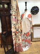 Two traditional Japanese kimonos in silk material with worked floral design (shoulders: 28cm x