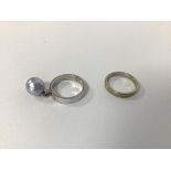 A pair of white metal rings, one with single pearl pendant, the other with inscription to