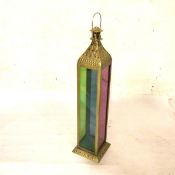 An Eastern brass embossed rectangular dome top candle lantern with coloured glass panelled sides, on