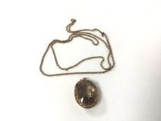 A yellow metal necklace (approximately 30cm) and a pendant set light grey stone in gilt metal mount