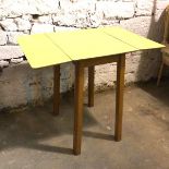 A mid century kitchen table with yellow drop leaf formica top on beech tapering supports (open: 78cm