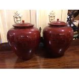 A pair of modern papier mache lidded urns, with an oxblood ground (48cm) (2)