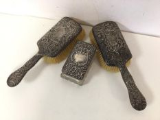 An Edwardian pair of dressing table brushes, both with rococo style backs depicting thistles,