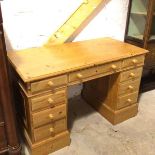 A modern pine twin pedestal kneehole desk, the top with moulded edge above a centre frieze drawer,