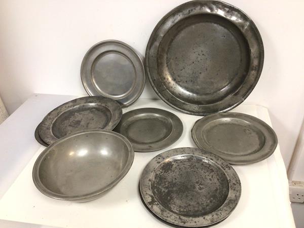 A group of pewter plates including an alms dish (damage to edge), eight additional plates, most with