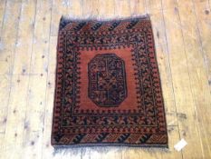 An Afghan mat with single gul surrounded by multiple borders, on burnt orange field (60cm x 66cm)