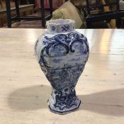 An early 19thc Delft pottery baluster vase with moulded C scroll cartouches, decorated with a Figure