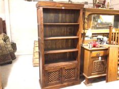 An Eastern hardwood upright open bookcase, the top with moulded edge above four open shelves and