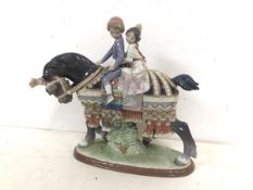 A Lladro figure, Couple Riding Horse in Elaborate Attire (26cm x 27cm x 9cm)