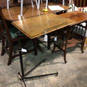 An Edwardian cast iron and oak adjustable reading/bed table on shaped outswept cast iron