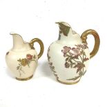 A Royal Worcester caneware jug decorated with floral handpainted sprays, with gilt handles and