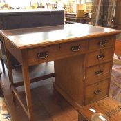 An Edwardian single pedestal kneehole desk, the rectangular top with inset skiver above a bank of