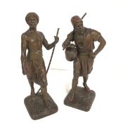 After Debus, a pair of spelter cast figures, one holding a staff, the other a ewer, raised on