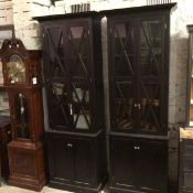 A pair of Oka style black ash upright bookcases with moulded cornices above a pair of glazed