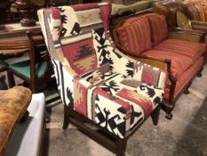 A dark stained wood modern wing easy chair upholstered in kelim fabric, on square tapered